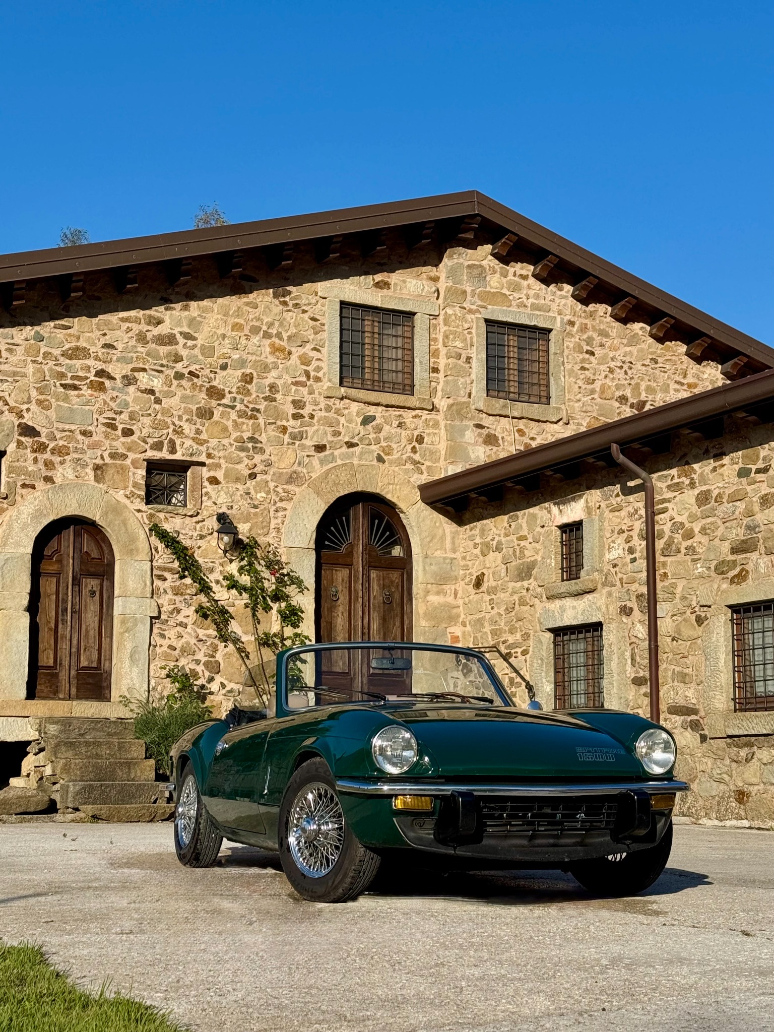 La Triumph Spitfire 1500 davanti a una dimora in pietra